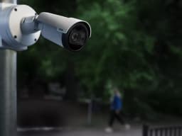 AXIS P1488-LE from AXIS COMMUNICATIONS - Bullet Camera mounted on a pole infront of a park during night